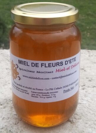 Pot de miel de fleurs d'été Miel et Délices, montrant sa texture liquide, limpide et sa couleur dorée. Ce miel doux aux arômes floraux est un classique polyvalent, récolté artisanalement en Hérault.